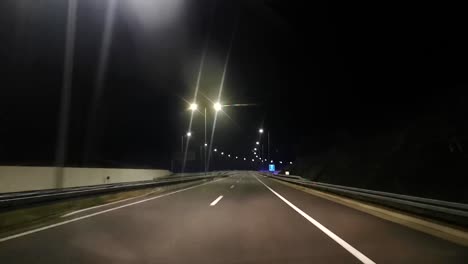 Nachtfahrt-Auf-Einer-Beleuchteten-Autobahn-Mit-Zwei-Fahrspuren