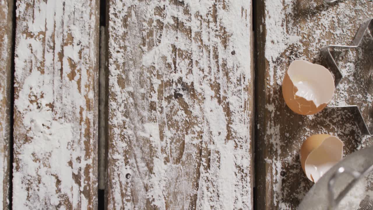 vídeo de ingredientes para hornear y herramientas acostadas en una superficie de madera con harina