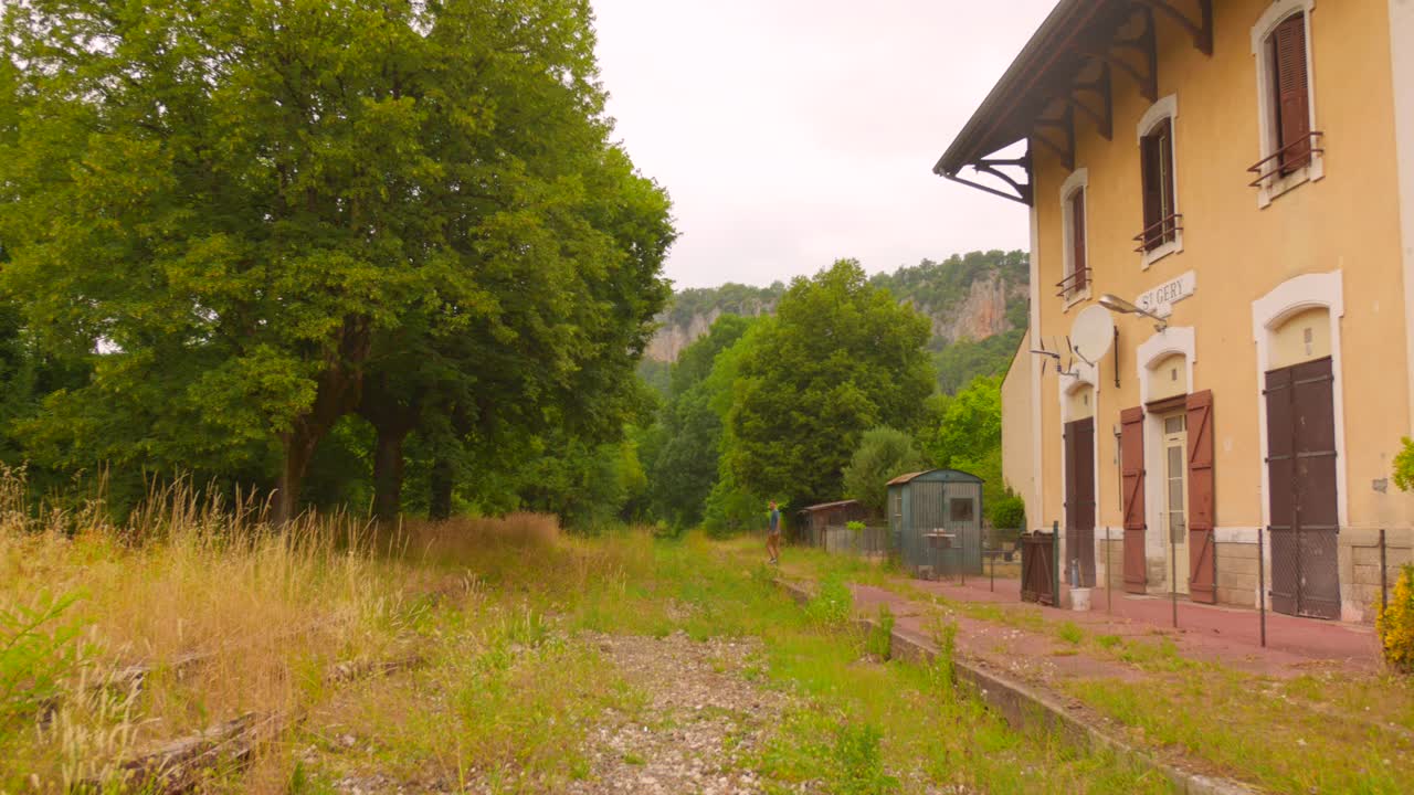 View of former railway station in Saint-Géry, France surrounded with lush greenery