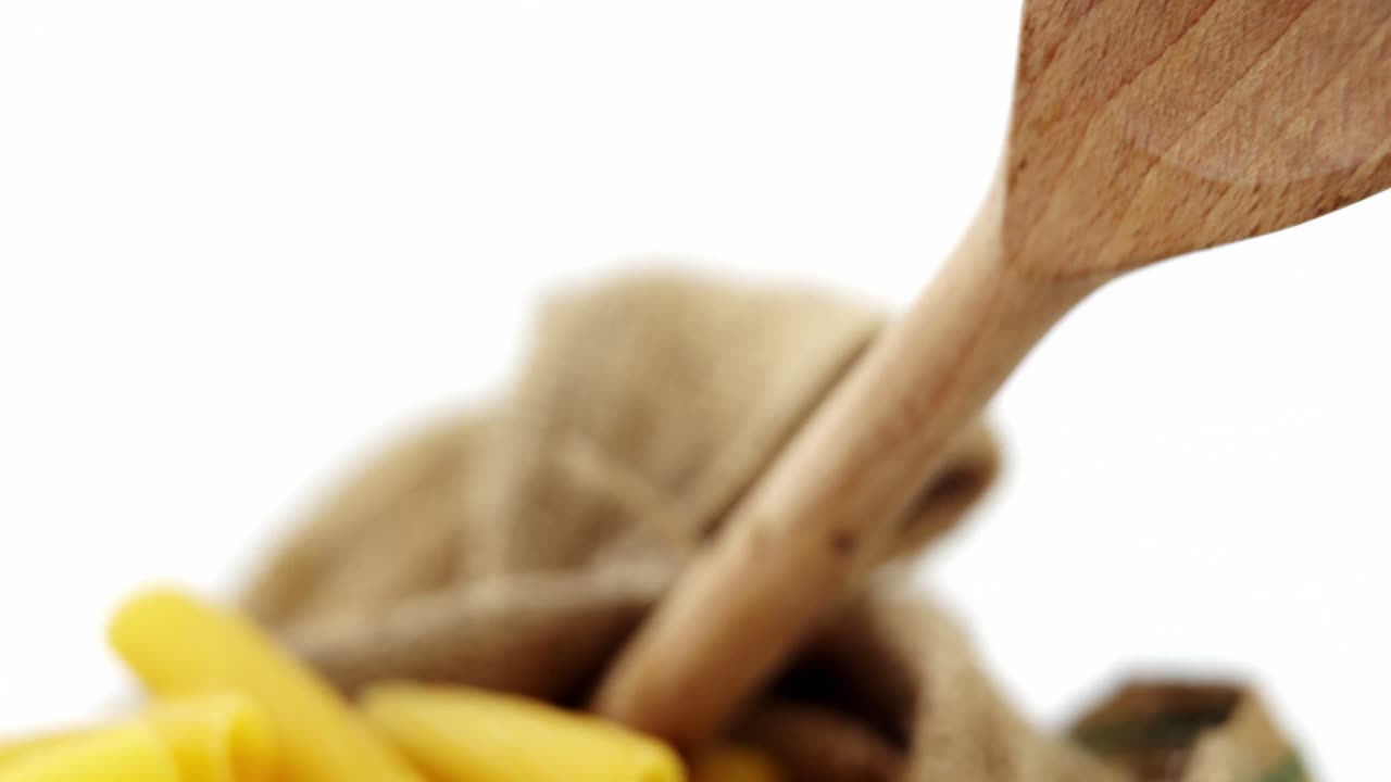 Close-up of raw pasta with wooden spoon