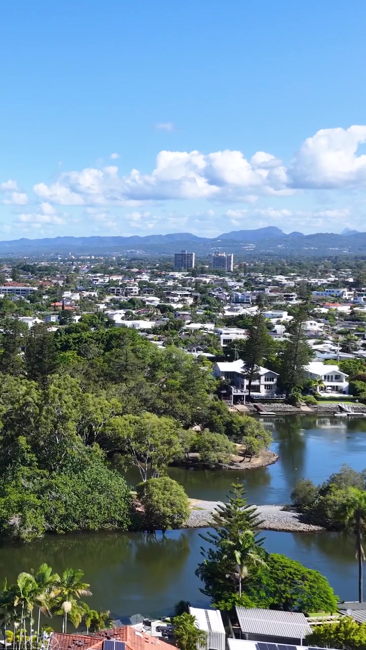 Vista aérea panorámica de una ciudad residencial con río y montañas distantes