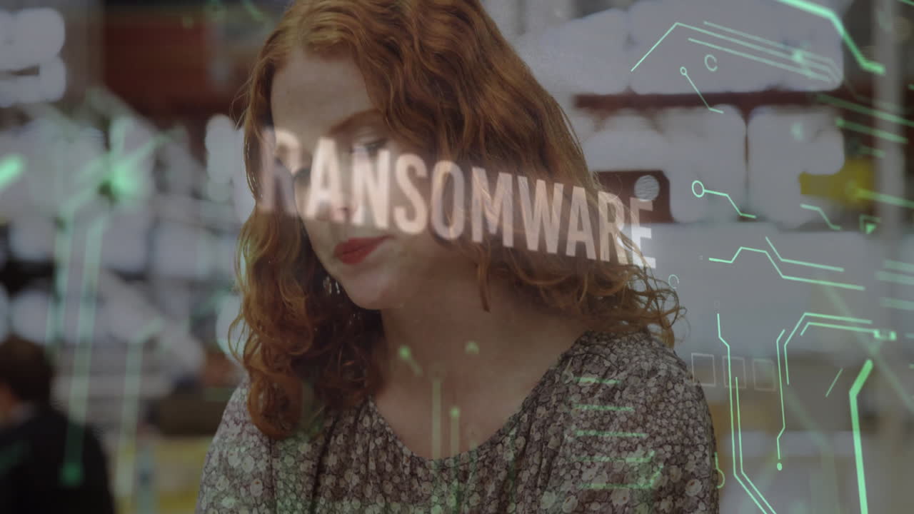 In office, woman with curly hair reading ransomware animation on computer screen