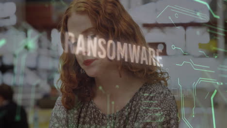 In office, woman with curly hair reading ransomware animation on computer screen
