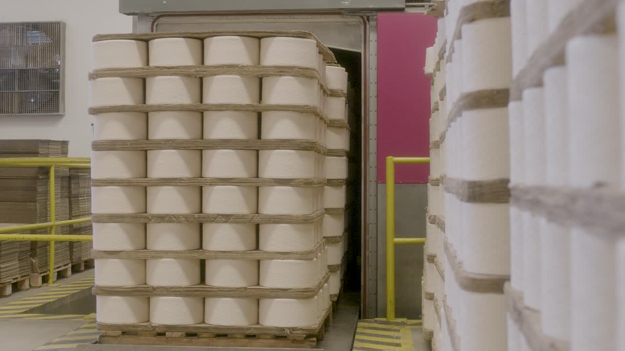 Magazzino tessile industriale con coni di filato di cotone impilati.