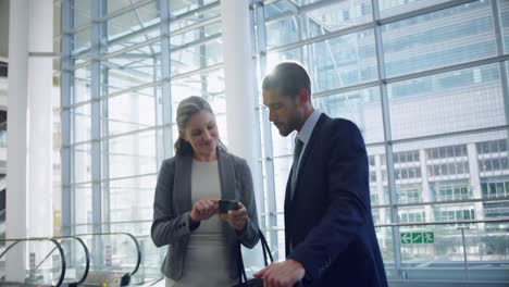 Businessman-and-businesswoman-shaking-hands-with-each-other-in-the-lobby-at-office-4k