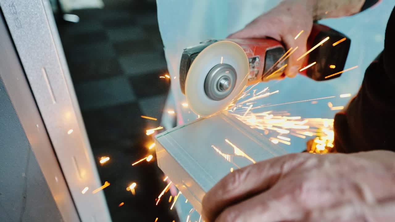 Close-up slow mo, craftsman grinding sharp edge from metal piece, sparks flying