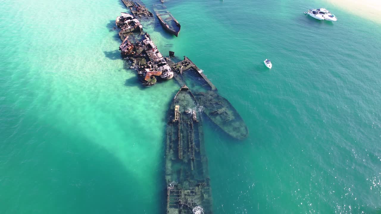 Detailed aerial shot of Tangalooma Wrecks, showcasing historic ship remains in vibrant turquoise waters.