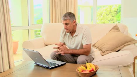 Mature-man-getting-good-news-on-his-laptop