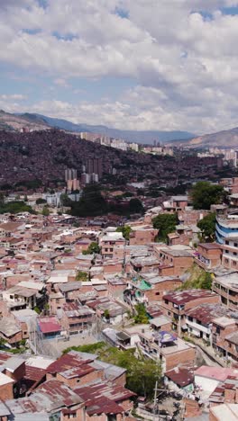 aerial flying over comuna 13, a neighborhood known for its colorful houses and vibrant street art in medellin. vertical video