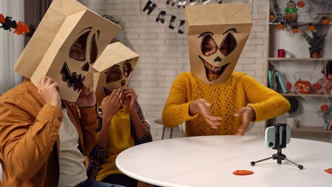 people in diy paper bag halloween costumes recording video