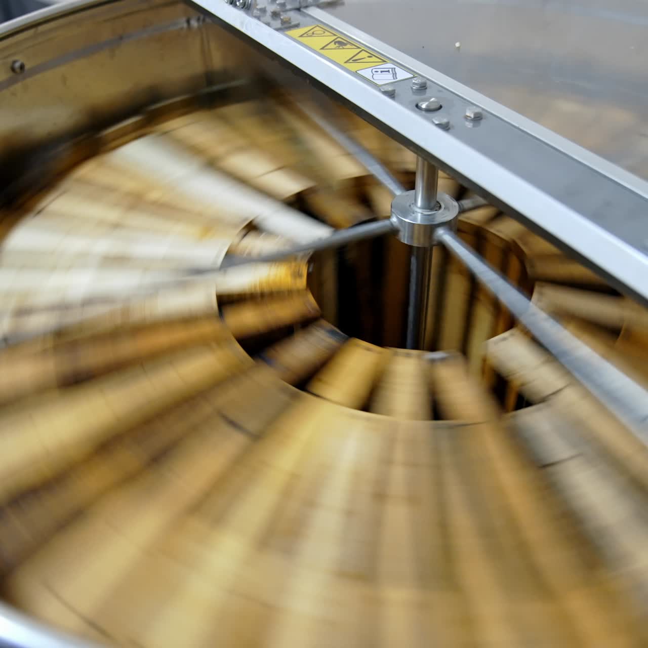 Honey pumping. Centrifuge device that spinning honey from honey cells. Honey extractor is orbiting with frames with honeycombs. Getting honey from honeycomb