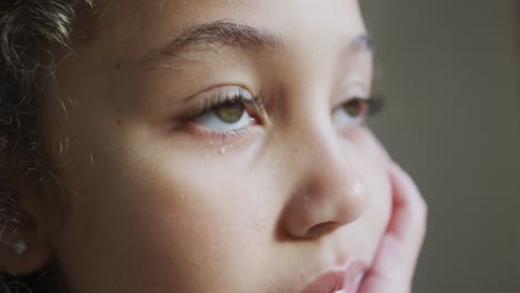 mixed race thoughtful girl, sitting in living room