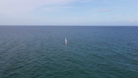 vuelo aéreo al velero blanco solo en el océano atlántico azul y tranquilo