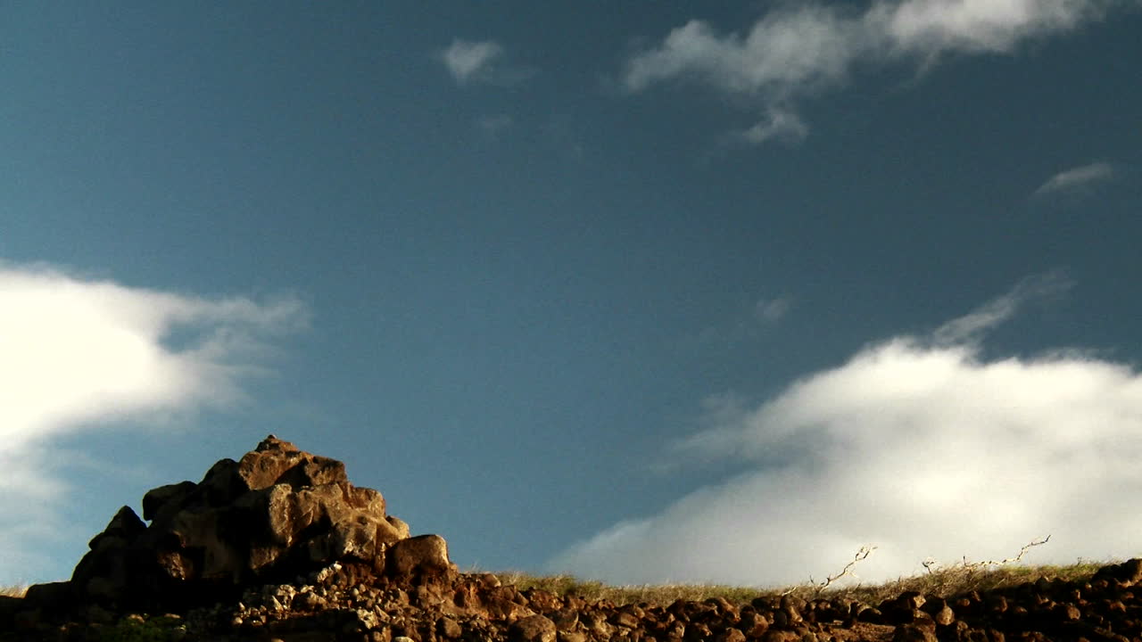시간 경과에 구름이 산 꼭대기에 떠 있습니다.