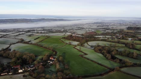 Toma-Aérea-Hacia-Atrás-De-La-Campiña-De-Otter-Valley-En-Devon,-Inglaterra,-En-Una-Mañana-Helada