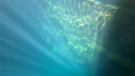 A-Rock-Wall-Under-The-Sea-With-Light-Rays-Passes-Through-The-Water