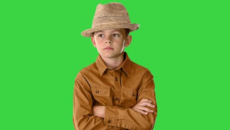 boy in a shirt and straw hat posing with crossed arms and then putting arms on his hips on a green screen, chroma key