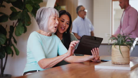 Happy,-senior-mother-and-daughter-on-tablet