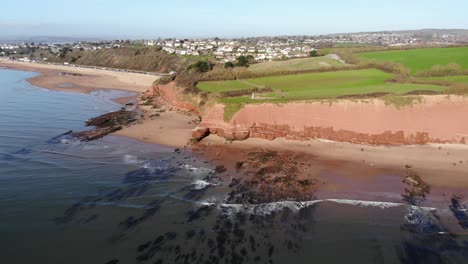 Aerial-View-Of-Orcombe-Beach-And-Cliff-Coastline-In-Exmouth-With-Visitors-On-Beach-On-Sunny-Day