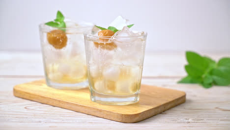 Jugo-De-Ciruela-Helado-Con-Soda-Y-Menta-En-La-Mesa-De-Madera---Bebida-Refrescante