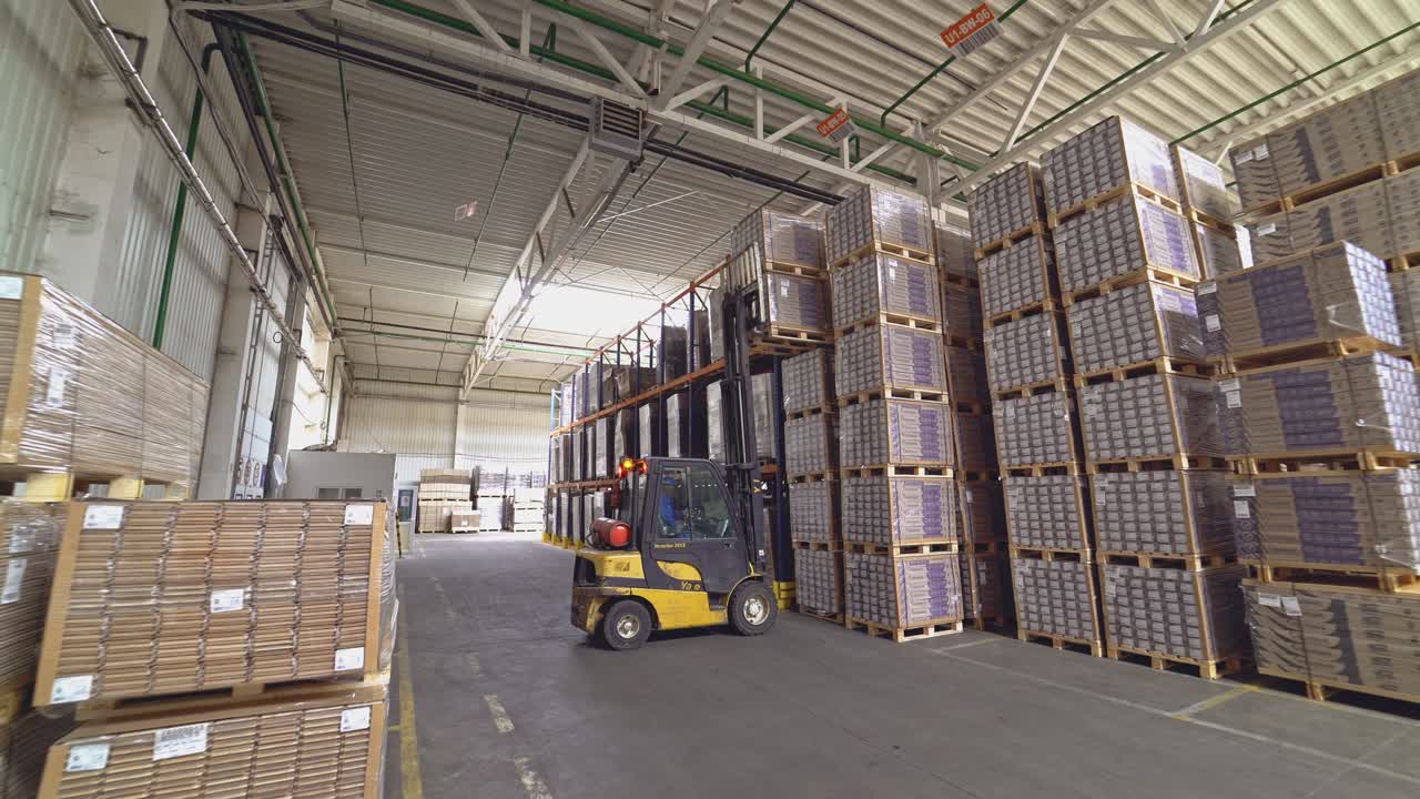 Forklift truck pulled up to a pile of wooden pallets. Large industrial enterprises department