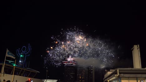 outdoor drone lightshow at night with pyrotechnic fireworks on new year eve