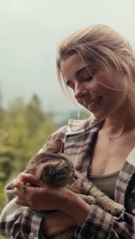 woman holding a cat outdoors