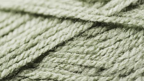 Micro-video-of-close-up-of-green-woolly-threads-with-copy-space