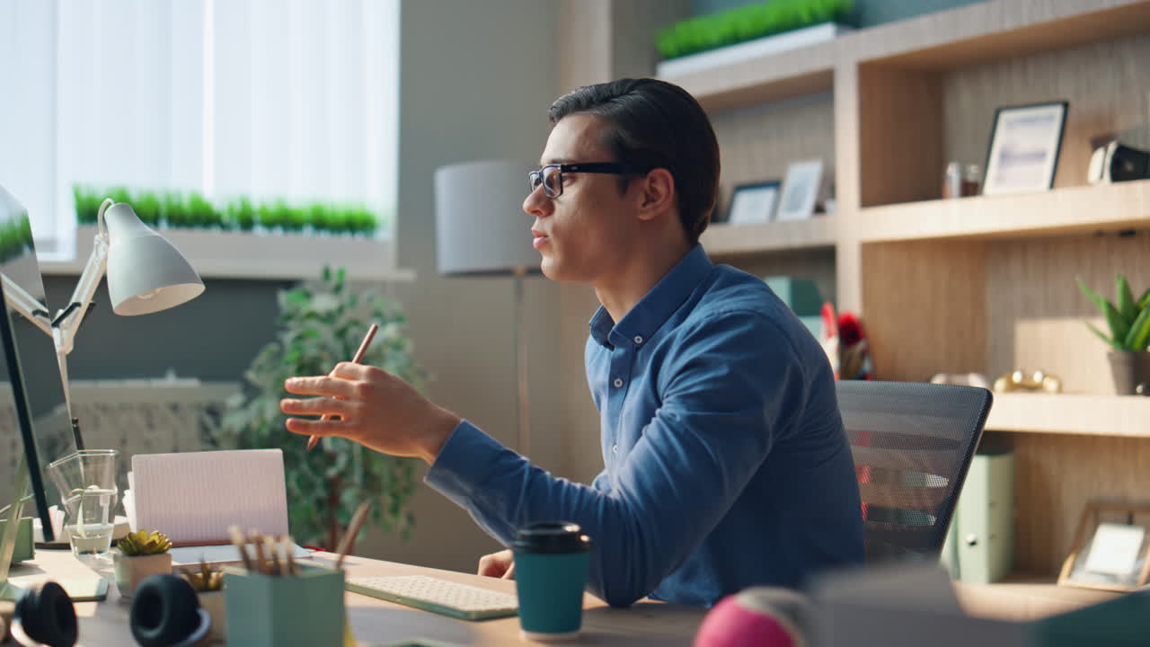 オフィスでのフレンドリーなクリエイターによるPCビデオ通話。ポジティブなデザイナーが手でジェスチャー。
