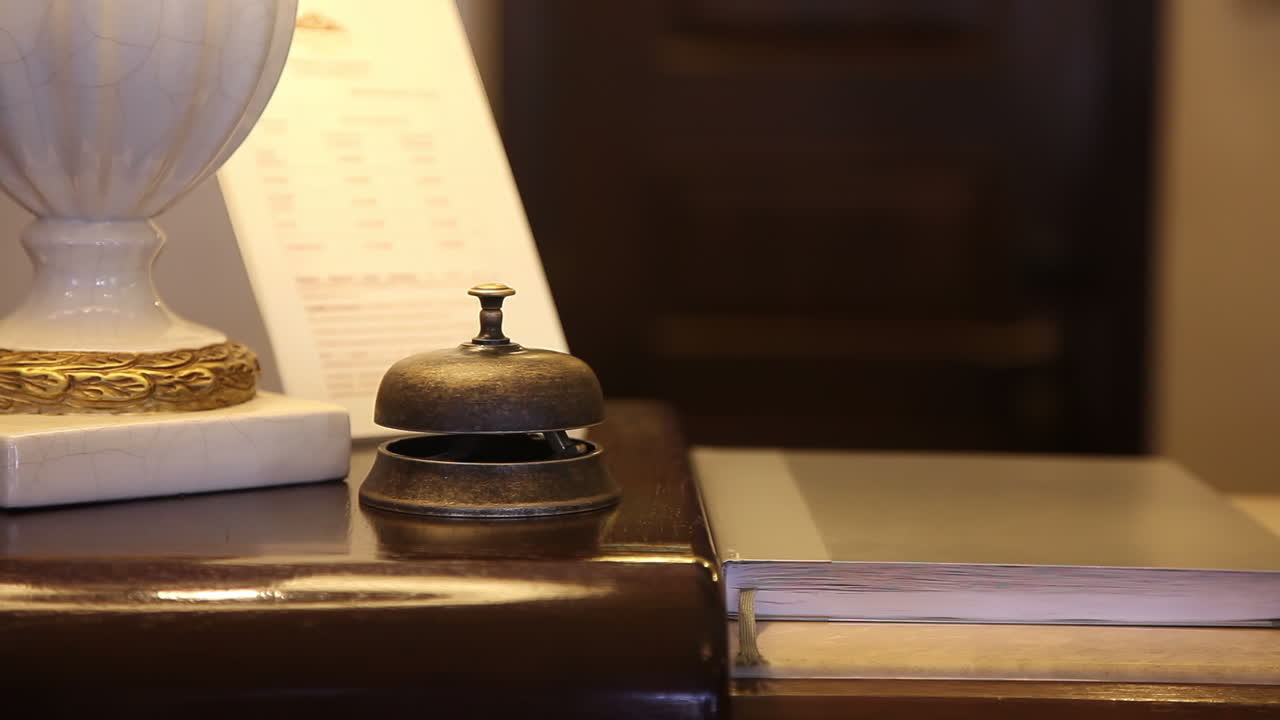 mesa de recepción del hotel con campana y invitado