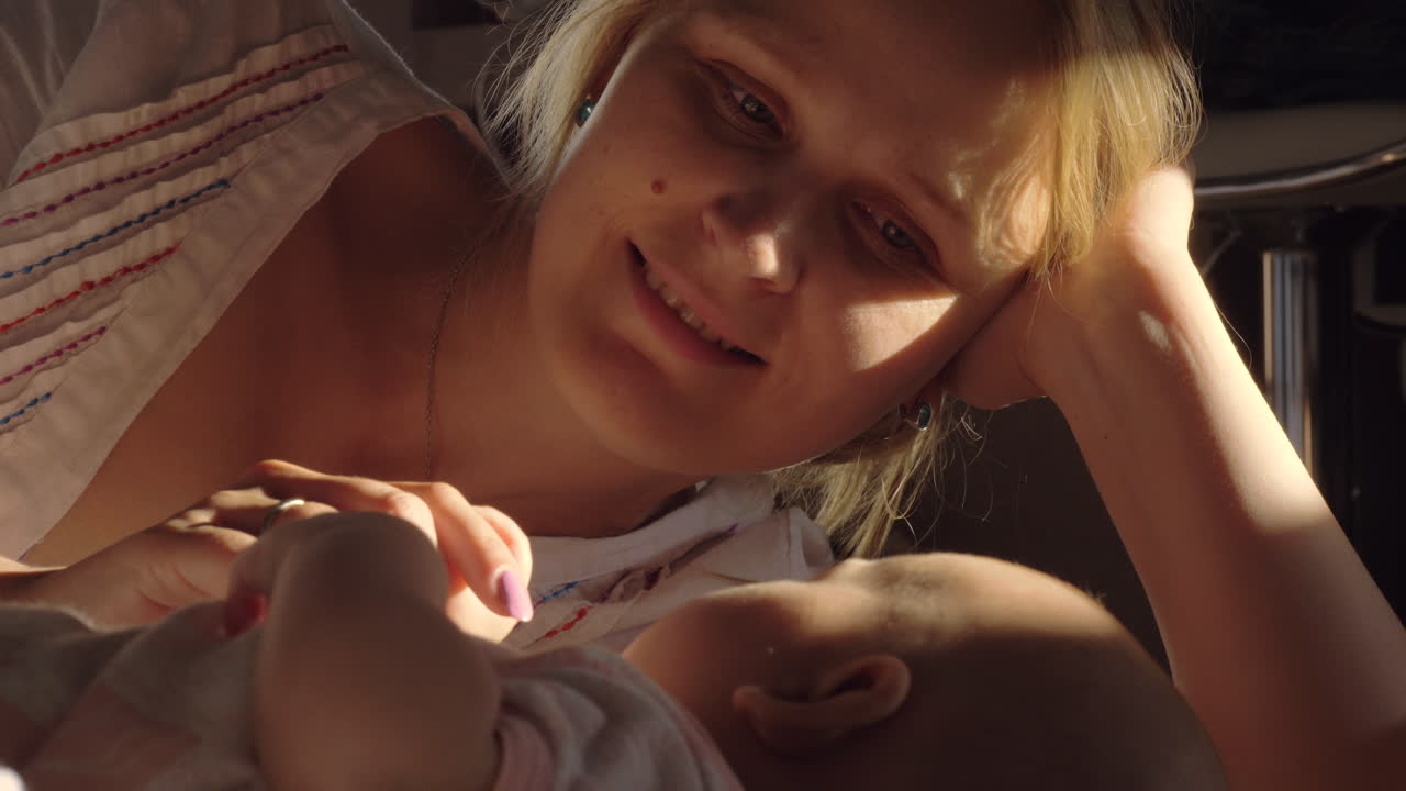 Happy mother looking at baby with love