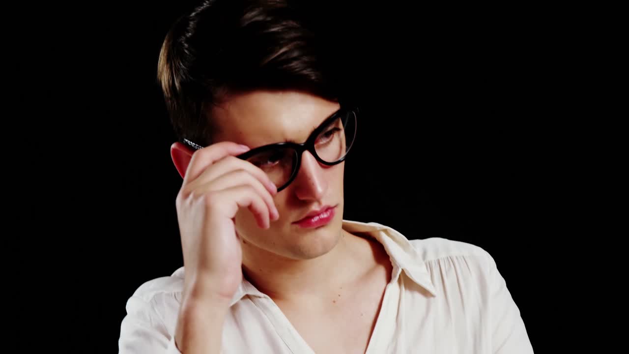 hombre andrógino posando contra un fondo negro