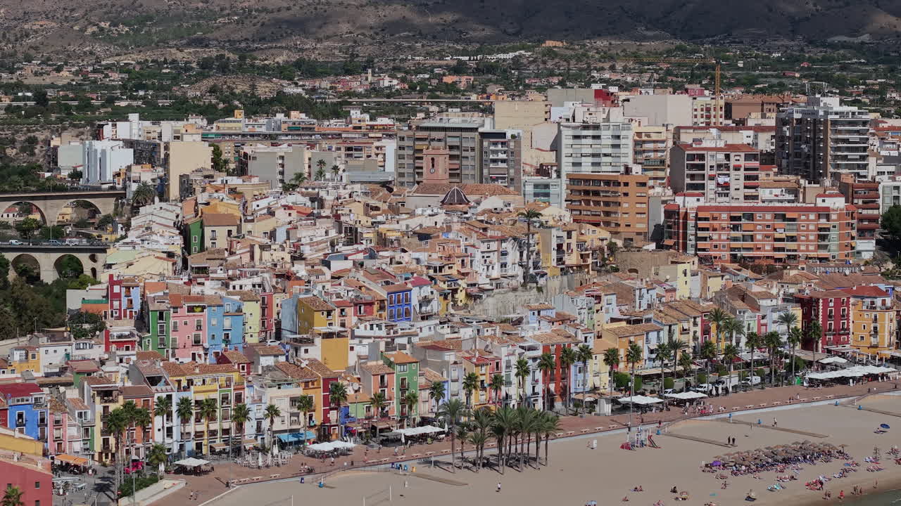 Vista aerea di Villajoyosa La Vila Joiosa, Spagna, città costiera mediterranea con case colorate, lungomare di palme e costa con spiaggia sabbiosa. Filmato 4K di alta qualità.
