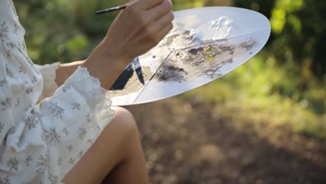 a Middleaged Woman Artist in Nature Paints a Picture a Middleaged Woman Artist in Nature Paints a Picture Closeup High Quality Footage