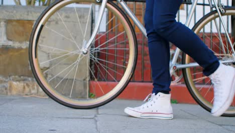 woman walking with bicycle in city street 4k