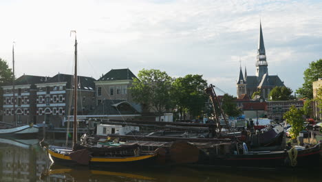 Old-Boats-Moored-In-The-Canal-In-Gouda,-The-Netherlands---wide