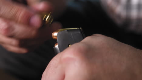 hombre cargando munición en un cargador de pistola
