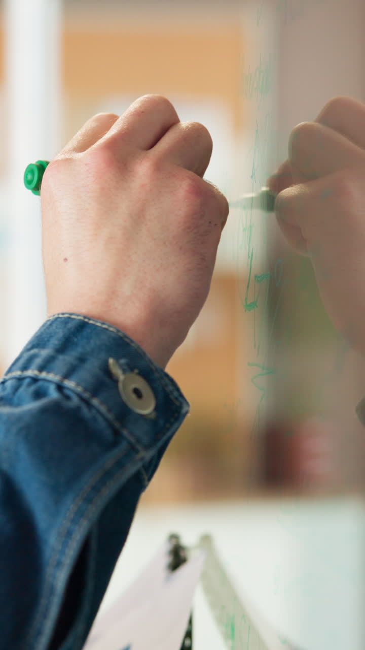 Close-Up of Hand Writing on Whiteboard with Green Marker