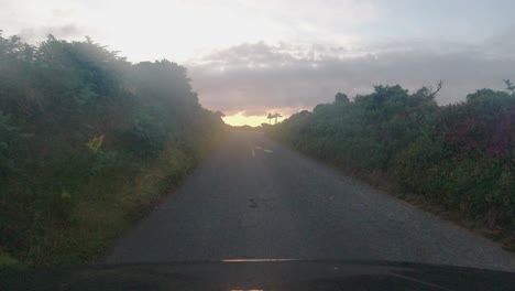 sunset pov car dashcam footage on countryside road with dramatic clouds and sea background devon uk 4k