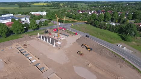 a drone flies over a large construction site on which a huge production hall is being built