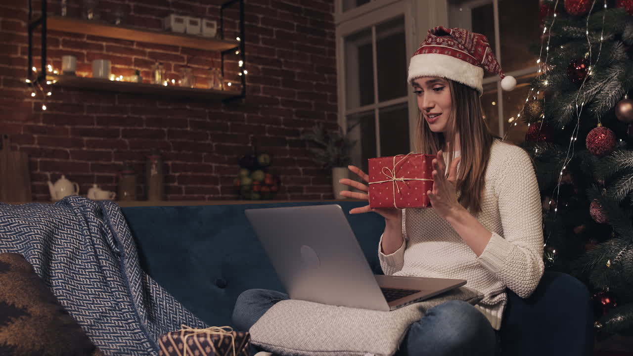 Woman on a video call with a gift at Christmas