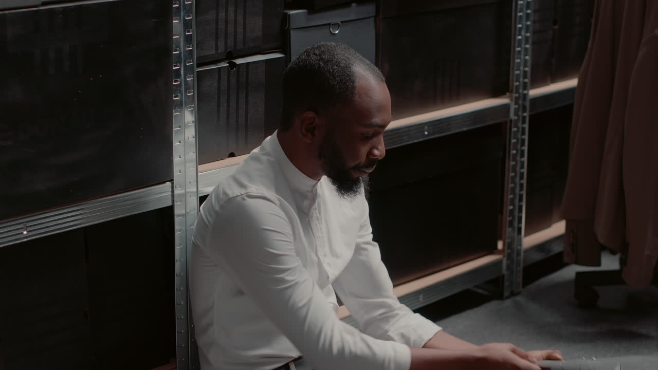 Man sitting on the office floor reviewing documents