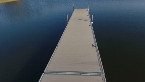 drone lento vuela sobre un pequeño muelle del lago