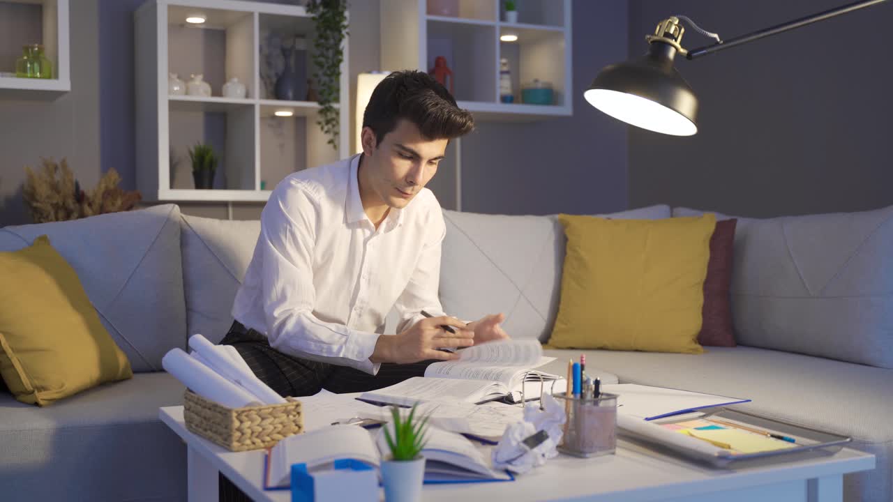 joven cansado trabajando en una oficina oscura. freelancer.