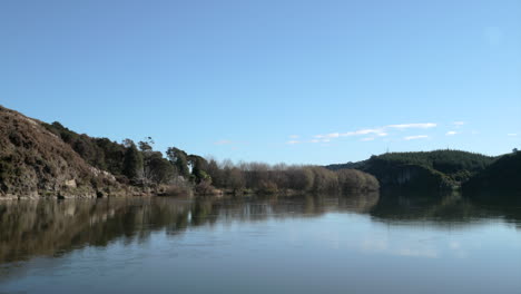 Ruhiger-Fließender-Fluss-Vom-Flussufer-Aus-Gesehen,-Blauer-Himmel