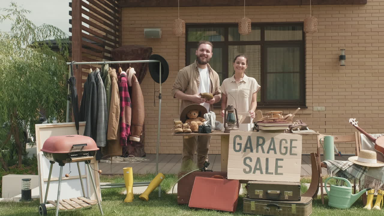 차고 판매 를 준비 하고 포즈 를 취하는 부부