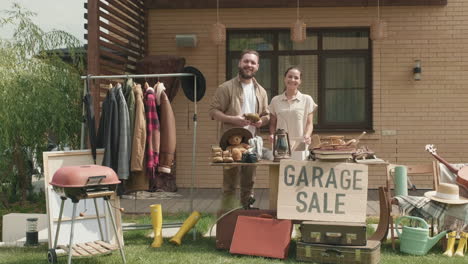 pareja preparándose para la venta de garaje y posando