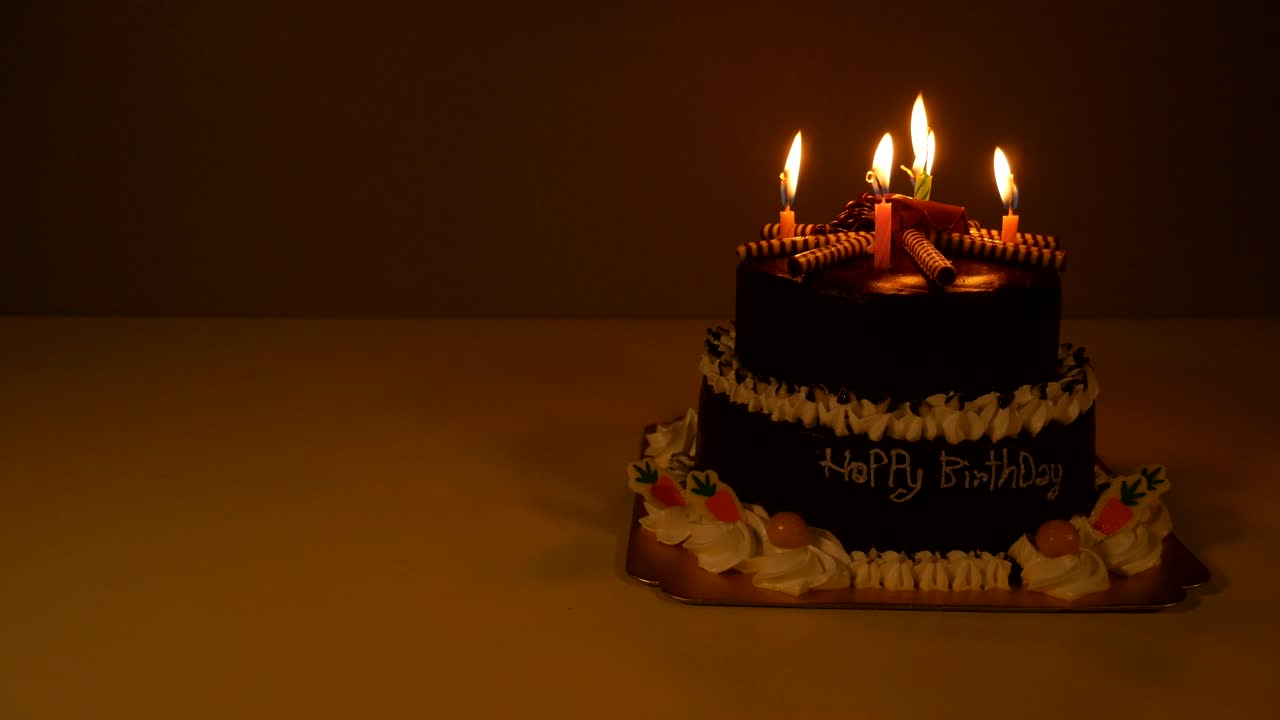 4k de feliz pastel de cumpleaños con velas en espiral encendidas
