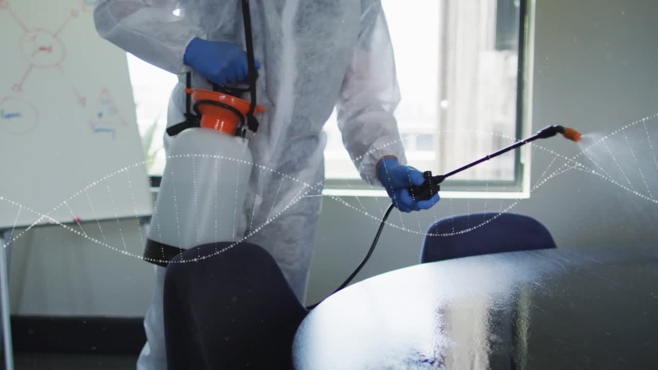 Temizlik görevlisi, püskürtücüyü yaklaştırıp etkinleştirerek toplantı masasını ve sandalyeleri dezenfekte etmek için sisliyor.