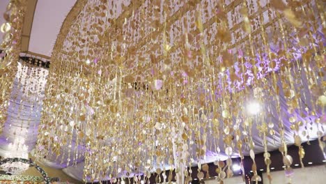 An-exquisite-gold-decoration-inside-a-wedding-hall,-attached-to-the-ceiling,-is-captured-in-a-close-up-shot